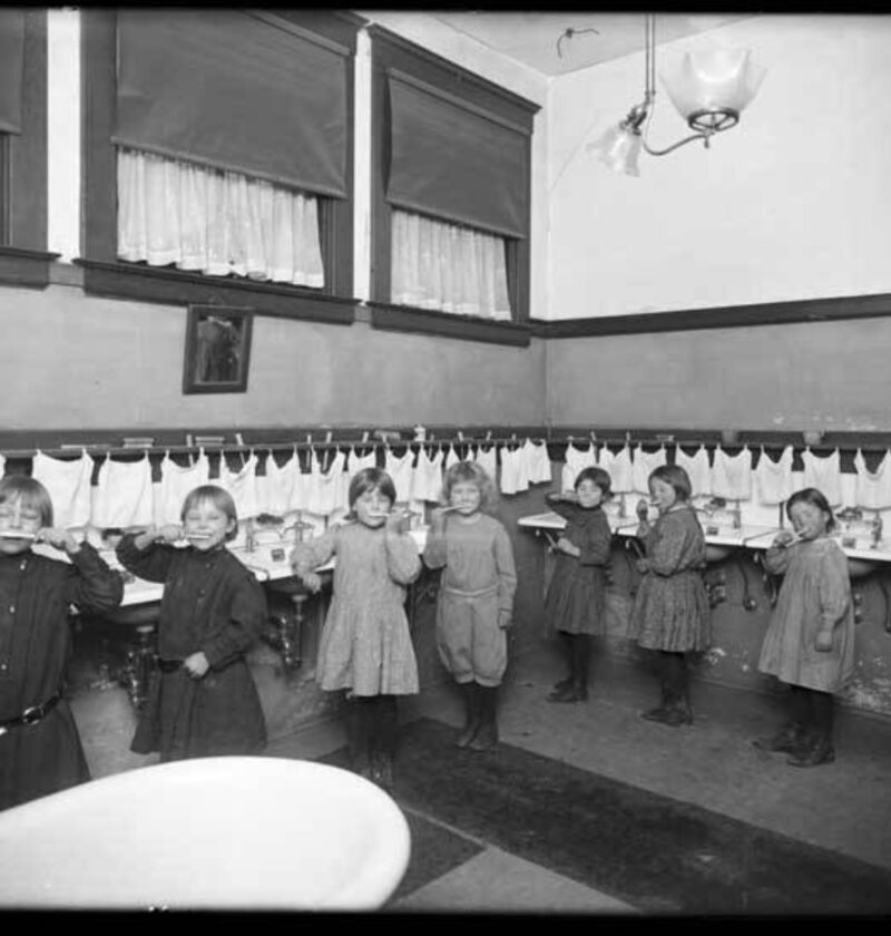 Enfants se brossant les dents dans un lavabo d'école, photo ancienne